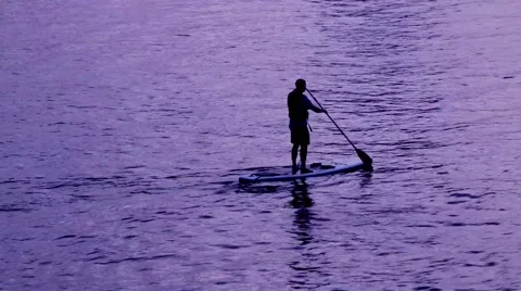 Man paddle boarding at sunset Stock Footage 66112710
