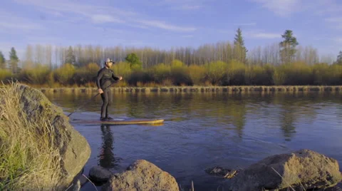 Man paddle boards past the camera Stock Footage 62844585