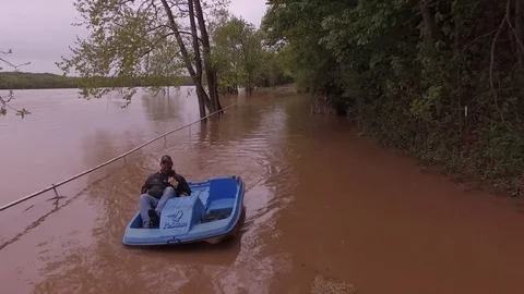 Man paddle boating down a flooded road Video stock 92279859