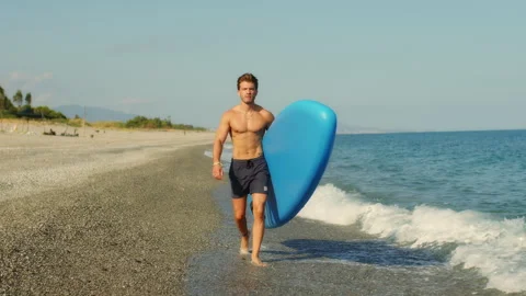 Man with paddle sup board on the beach Stock Footage 240553178