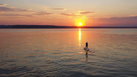A Man On A Paddleboard Touring On The River Against The Beautifull Sunset Stock Footage 115828429