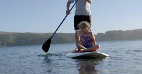 A man paddleboarding with his two young daughters. 스톡 동영상 88369380