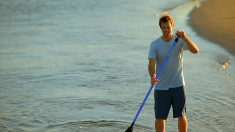 Man paddleboarding in the shallows. 스톡 동영상 88368354