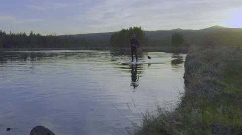 Man paddles board in front of camera Stock Footage 62865353