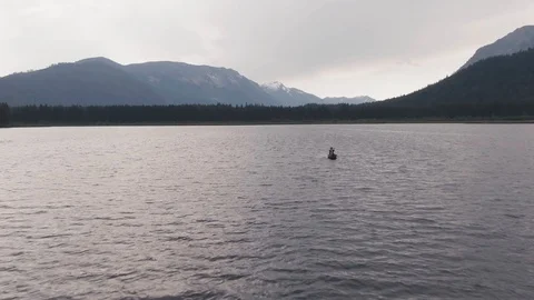 Man Paddles canoe through pristine mountain lake in the Cascades of Washington Stock Footage 111393175
