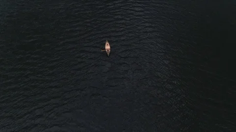 Man Paddles canoe through pristine mountain lake in the Cascades of Washington Stock Footage 111393482