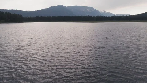 Man Paddles canoe through pristine mountain lake in the Cascades of Washington Stock Footage 111393727