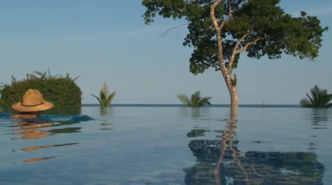 Man paddling across infinity pool. Video stock 28838786