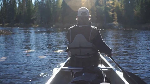Man Paddling Canoe down a  river in the Boundary Waters Stock-Footage 86395374