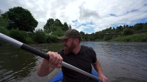 A man paddling a kayak on a river while talking to himself Stock Footage 253214014