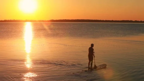 Man paddling in open water at sunset. Looping movie Stock Footage 90909986