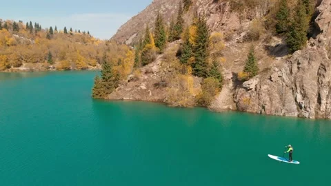 Man is paddling on Sup board in the mountain lake Stockbeeldmateriaal 141055791