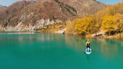 Man is paddling on Sup board in the mountain lake Stockbeeldmateriaal 141056155