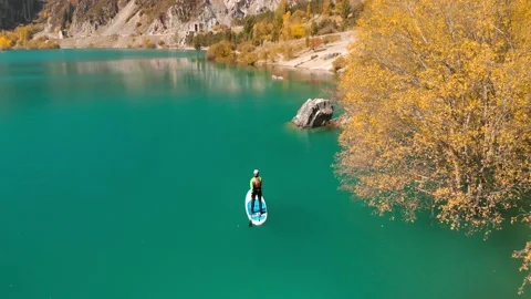 Man is paddling on Sup board in the mountain lake Видео 141056167