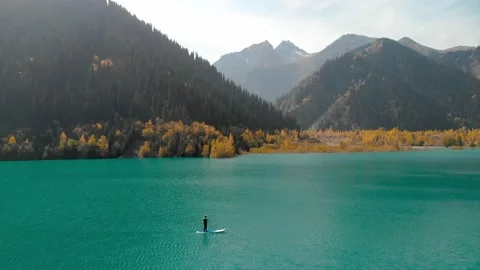 Man is paddling on Sup board in the mountain lake Stockbeeldmateriaal 141056306