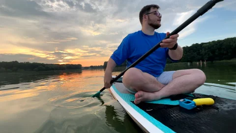 Man paddling on supboard on sunset Video stock 252180019