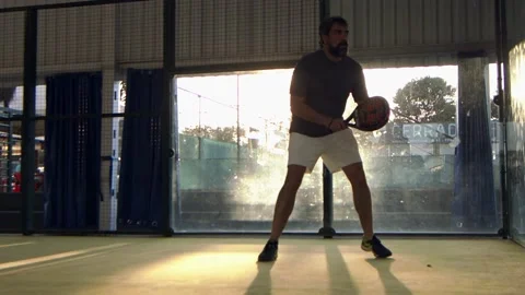 Man in a Padel match returns the ball off the back wall bounce Stock Footage 203834691