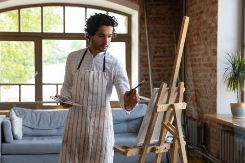 Man painter drawing on canvas in workshop Foto stock