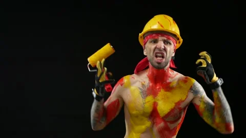 A man a painter a plasterer in a helmet and overalls painted with bright paint Stock Footage 150555216