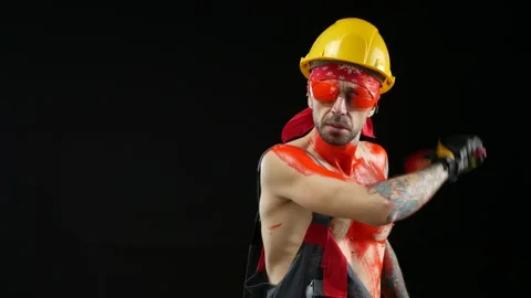 A man a painter a plasterer in a helmet and overalls painted with bright paint Stock Footage 150714116