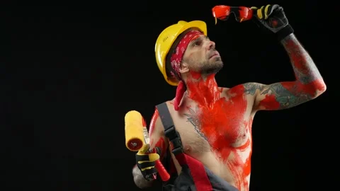 A man a painter a plasterer in a helmet and overalls painted with bright paint Stock Footage 150714117