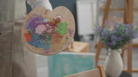 Man painter in studio holding paint palette with thumb and open hand, color.. Stock Footage 337376197