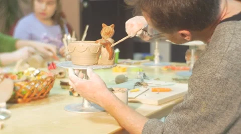 Man is Painting a Clay Cat Figurine Glazing a Pot by Brush Painting Attentively Stock Footage 59136341