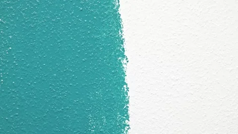 Man painting wall with blue roller, camera zooms in on detailed brush strokes Stock Footage 322135045