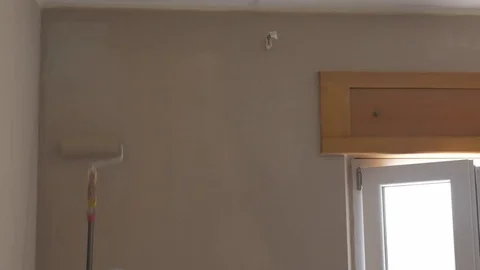 Man painting a wall with a roller Stock Footage 75790147