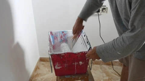 Man painting a wall, using paint and painting tools, no faces shown Stock Footage 134417093
