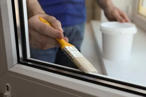 Man painting window frame at home, closeup Stock Photos