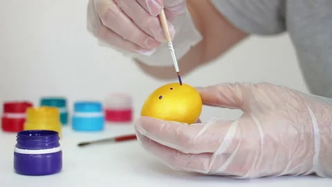 Man Painting a yellow Easter egg in polka dot with purple acrylic color Stock Footage 172143749