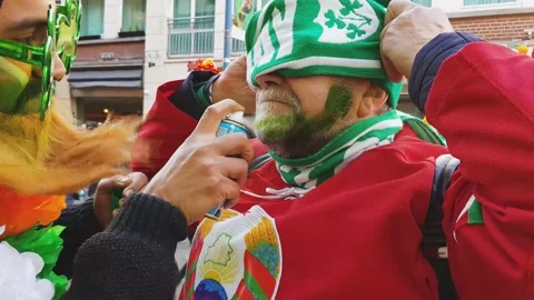 A man paints another man's beard green on St. Patrick's Day. Stock Footage 147206232