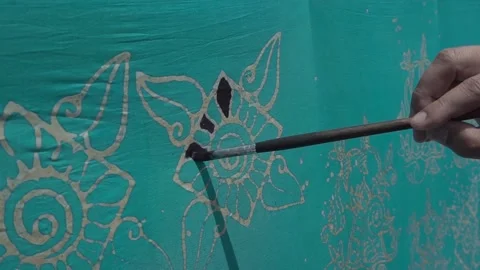 A man paints Batik with a brush Stock Footage 146761962