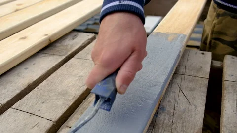 A man paints a board with paint. Selective focus. Stock Footage 309918562