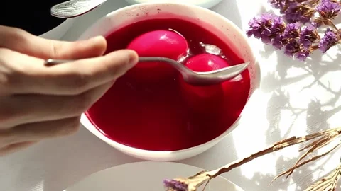 A man paints easter eggs in white plates in multicolored colors, minimalist Stock Footage 171788575