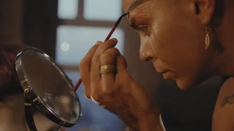 Man paints on his eyebrows in front of a mirror Stock Footage 275649176