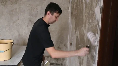 Man paints the plastered wall Stock Footage 83872385