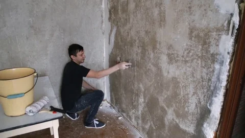 Man paints the plastered wall Stock Footage 83872486