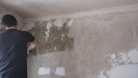 Man paints the plastered wall Stock Footage 83872600