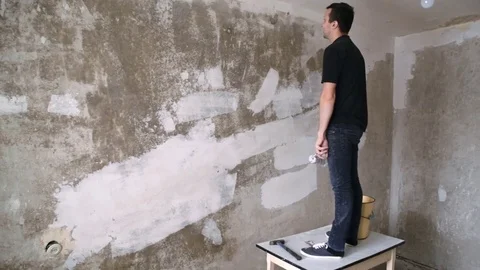 Man paints the plastered wall Stock Footage 83872747