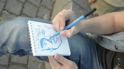 The man paints a portrait in a notebook. Stock Footage 51755194