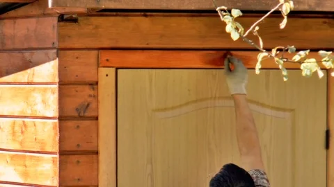 Man paints the trim with red paint Stock Footage 80754557
