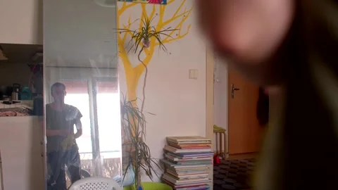 A man paints a vibrant tree mural, plays with reflection, and tidies Stock Footage 311206315