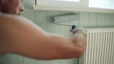 A man paints a wall with a roller. A man makes repairs in the room. Modern Stock Footage 157266686