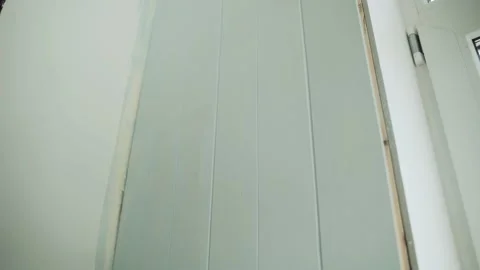 A man paints a wall with a roller. A man makes repairs in the room. Modern Stock Footage 157269399