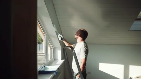 A man paints a wall with a roller. A man makes repairs in the room. Modern Stock Footage 157269852