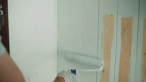 A man paints a wall with a roller. A man makes repairs in the room. Modern Stock Footage 157273599