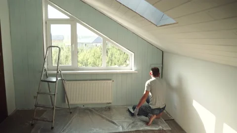 A man paints a wall with a roller. A man makes repairs in the room. Modern Stock Footage 157275281