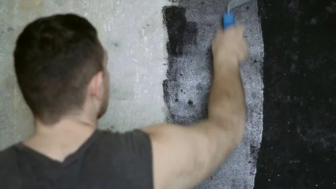A man paints a wall with a roller. Painter. 4k Stock Footage 88826656